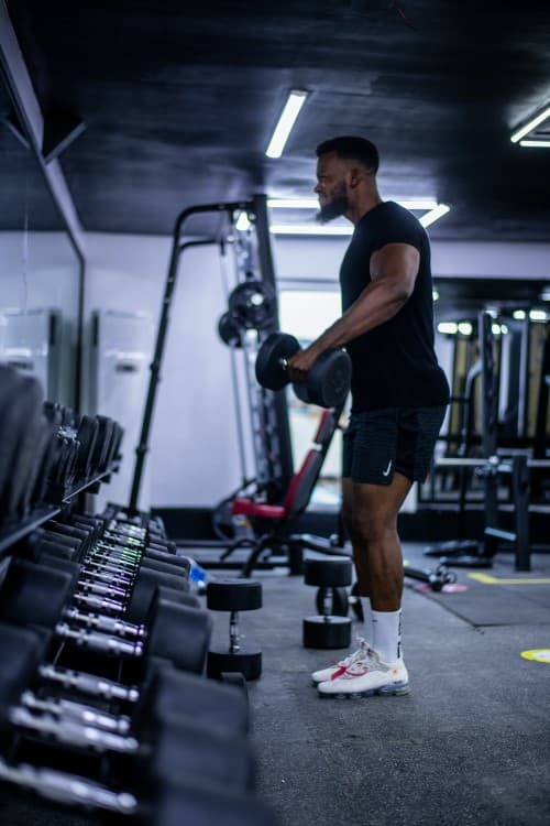 Persona entrenando con barra en un gimnasio